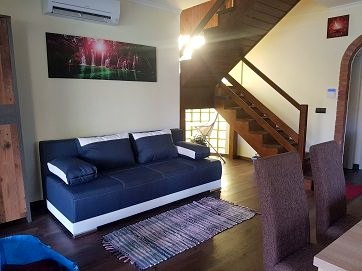 Das Wohnzimmer mit Sofa und Holztreppe