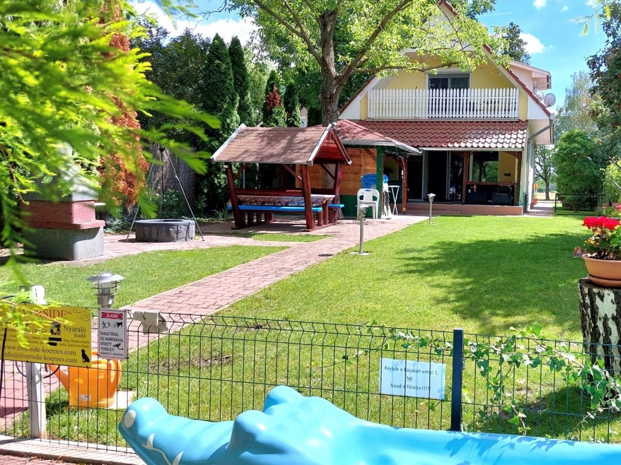 The house and the covered garden seating, seen from the lawn